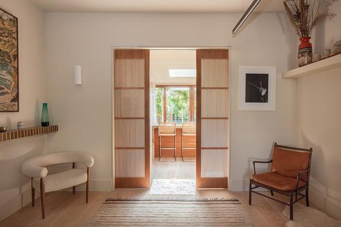 Natural tones link seating area to kitchen via clever pocket doors.