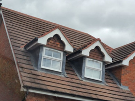 Gable end tiles and ridge tiles re-bedded and completed in red mortar Project image