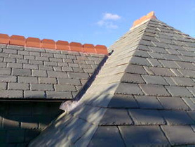 Random diminishing Green Slate Roof with mitred hips and vertical slating Project image