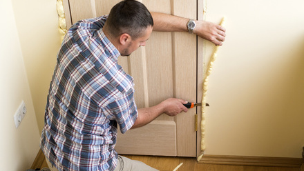 iStock retrofit green initiative man installing  insulation foam door.jpg