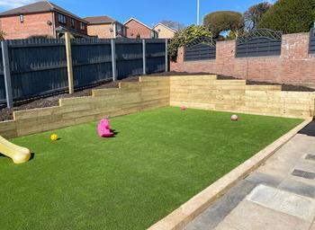 Railway sleeper retaining wall in child-friendly garden