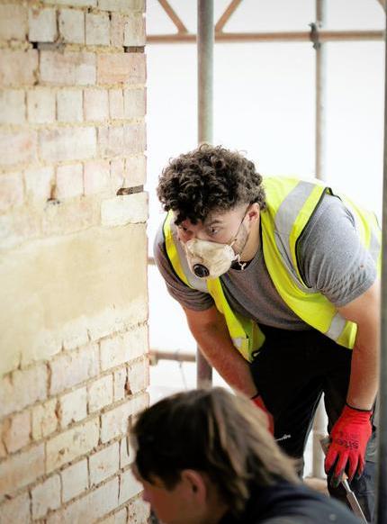Skilled builder on site inspecting brickwork - FMB member shoot Lambert Design.jpg
