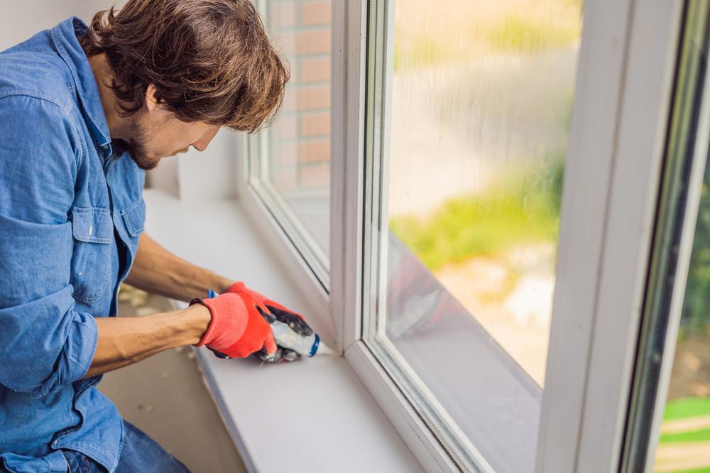 A builder fitting a window