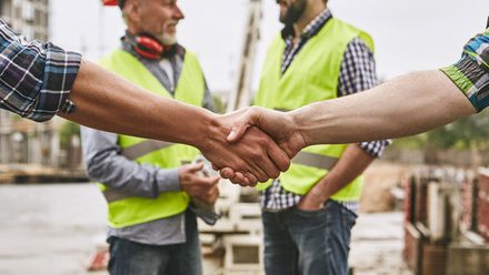 iStock builders handshake smiling building site.jpg